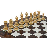 Rosewood chessmen inspired by 16th-century Indian history on a chessboard. Weighted pieces with billiard cloth bases for perfect balance.